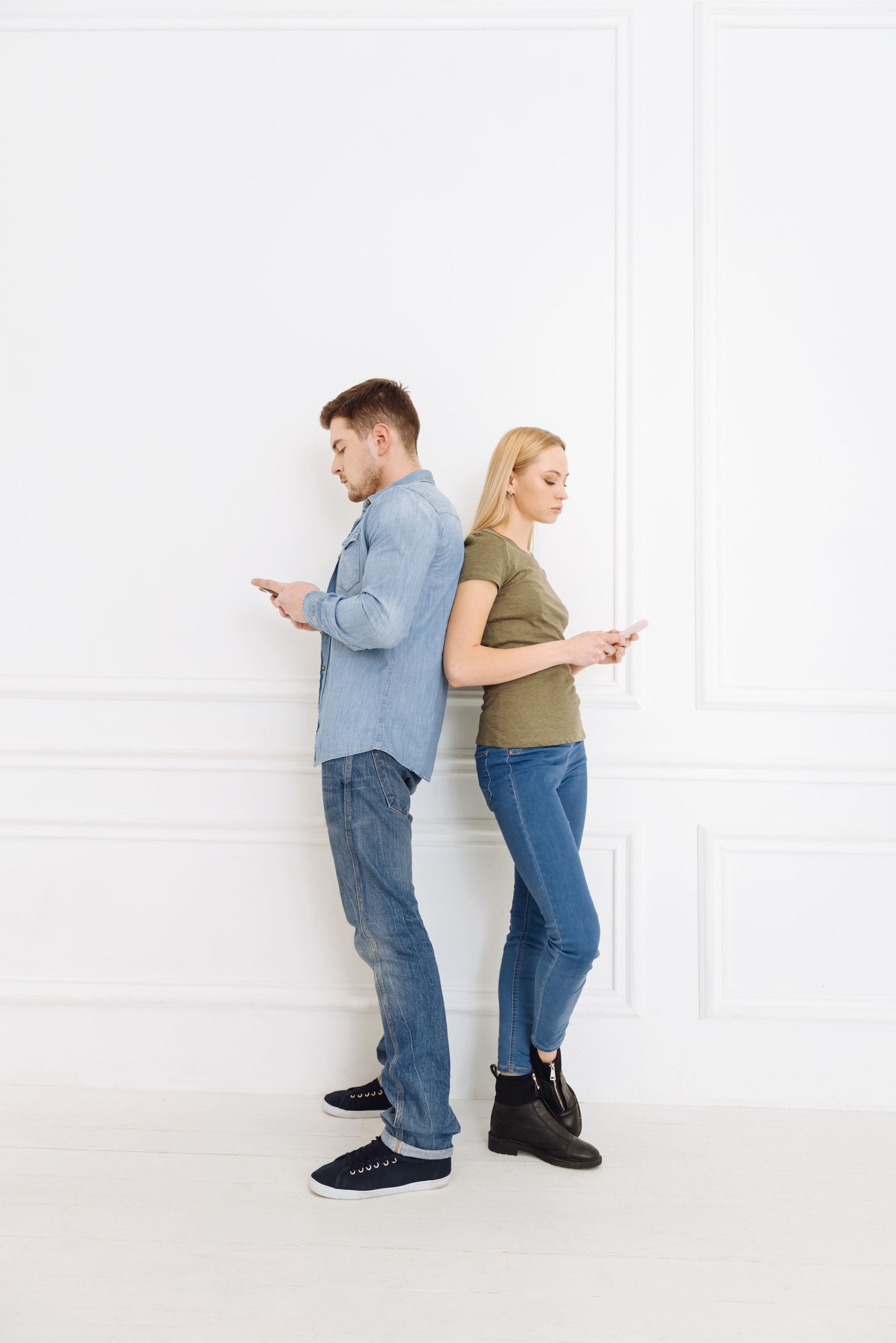 Upset couple standing against white background